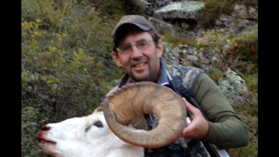 Tom Anderson with a Dall sheep ram in the mountains